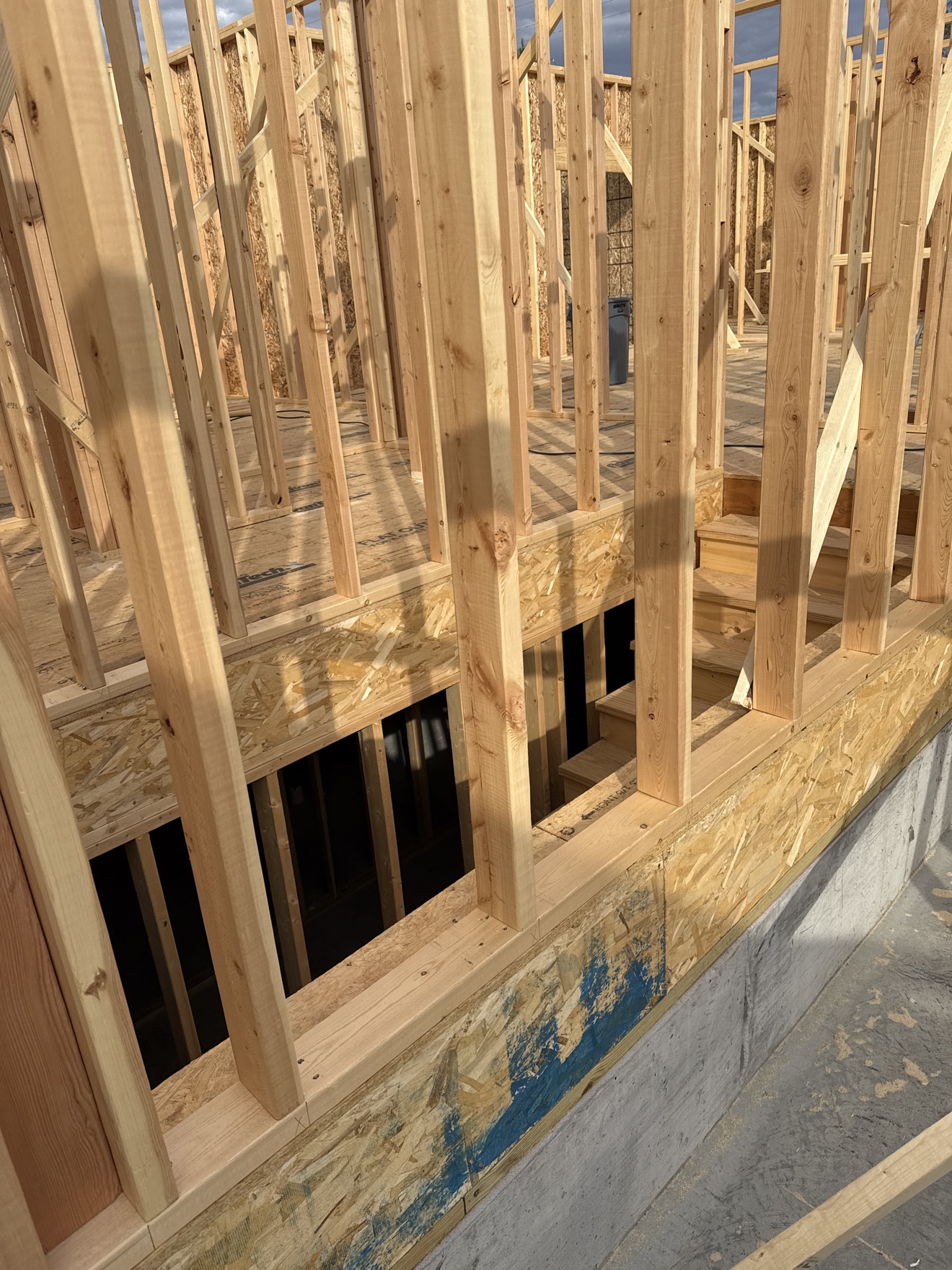 Close-up of wood wall studs, floor system, and subfloor on the current job
