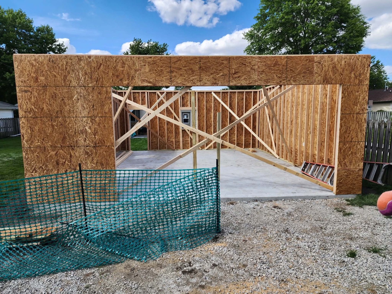 New framed walls and wide garage opening on a building addition