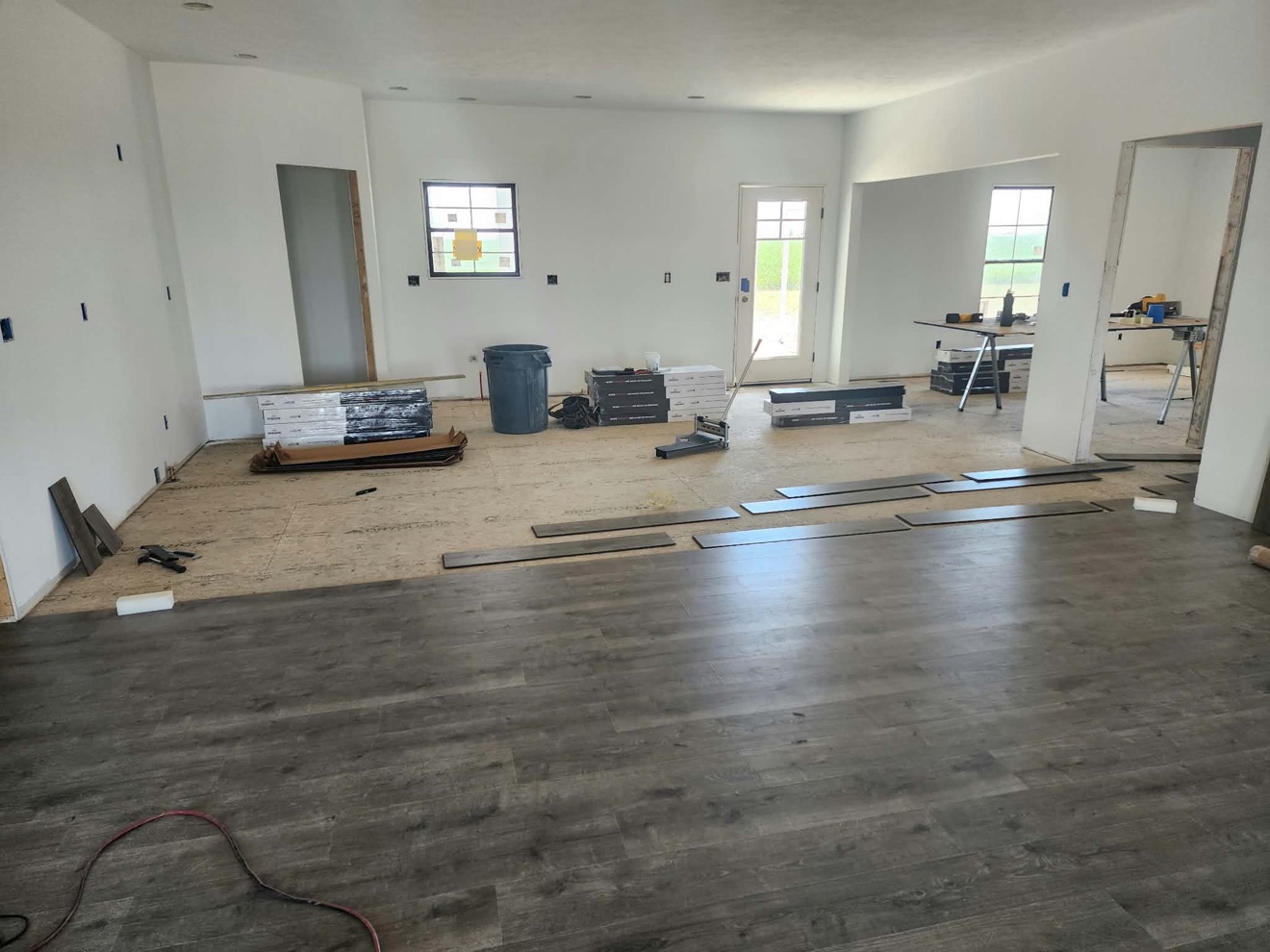 Finished dark plank flooring across an open kitchen and living area