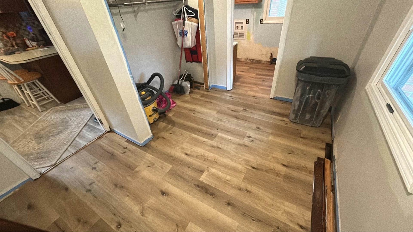 Wood-look plank flooring installed through a hallway and adjoining room