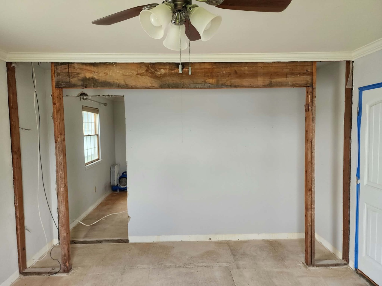 Interior wall opening framed with new lumber between two rooms