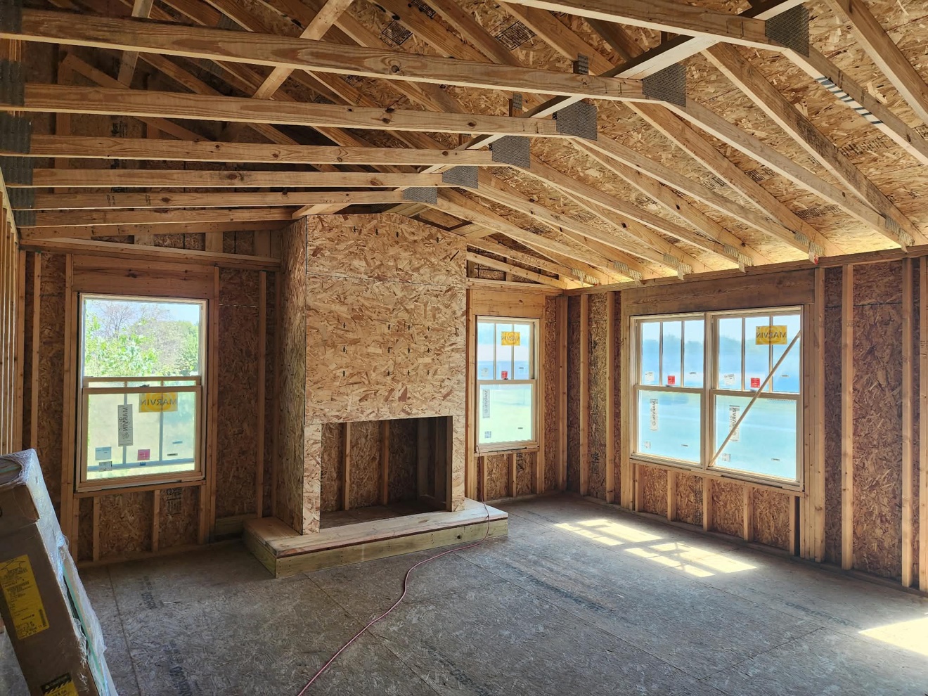 Interior room under construction with exposed wall studs and ceiling framing