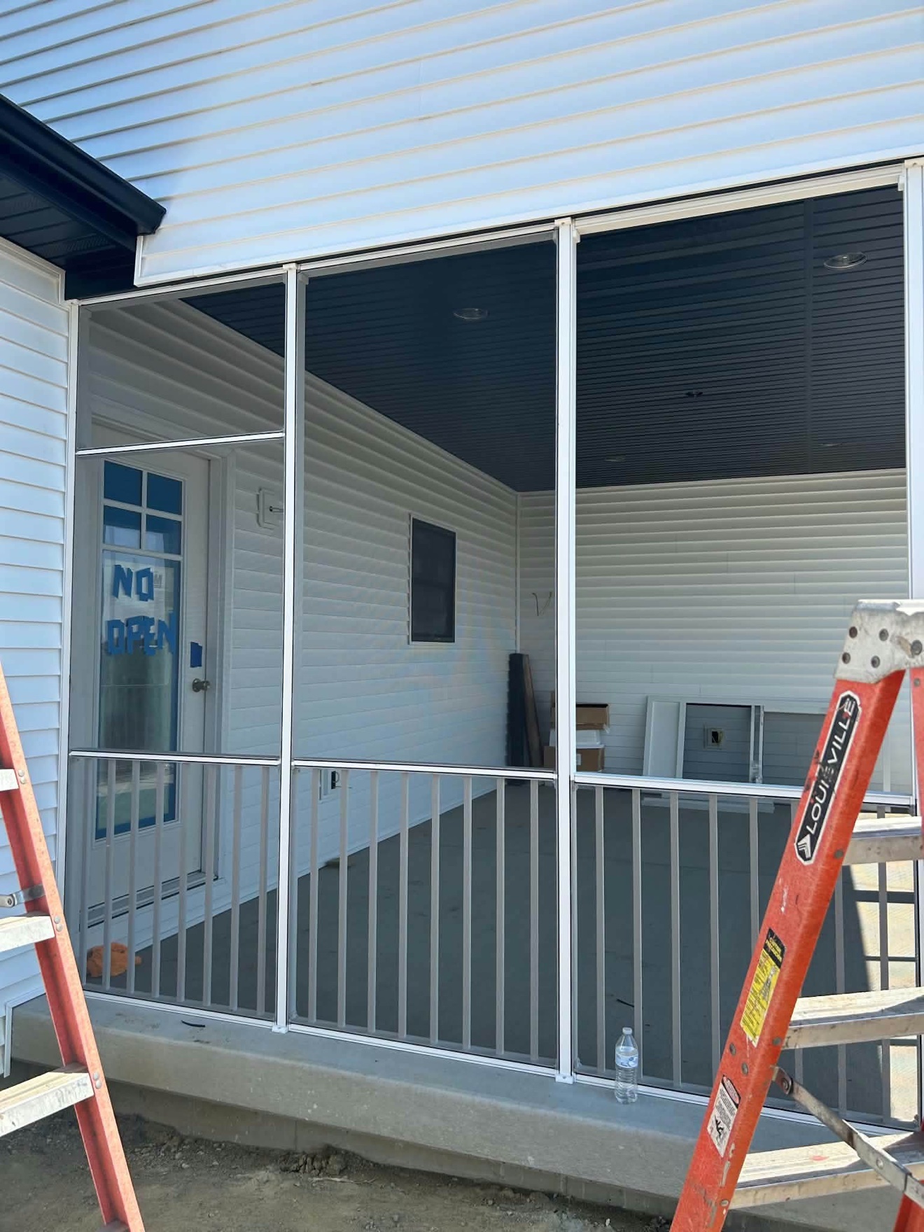 Covered screened porch with white siding and railing